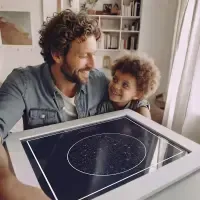 Father and son holding a Starrymaps star map print